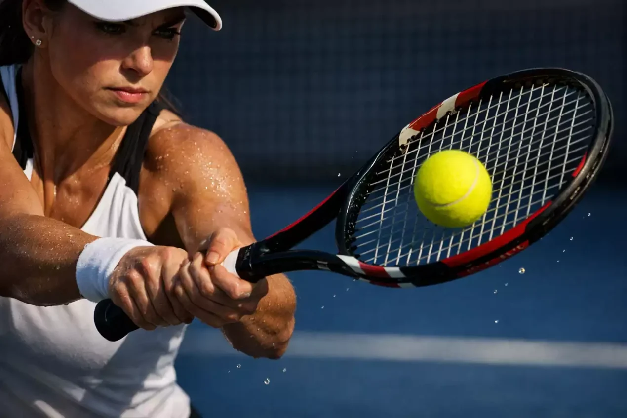 Tenista femenina golpeando un revés potente durante un partido oficial WTA