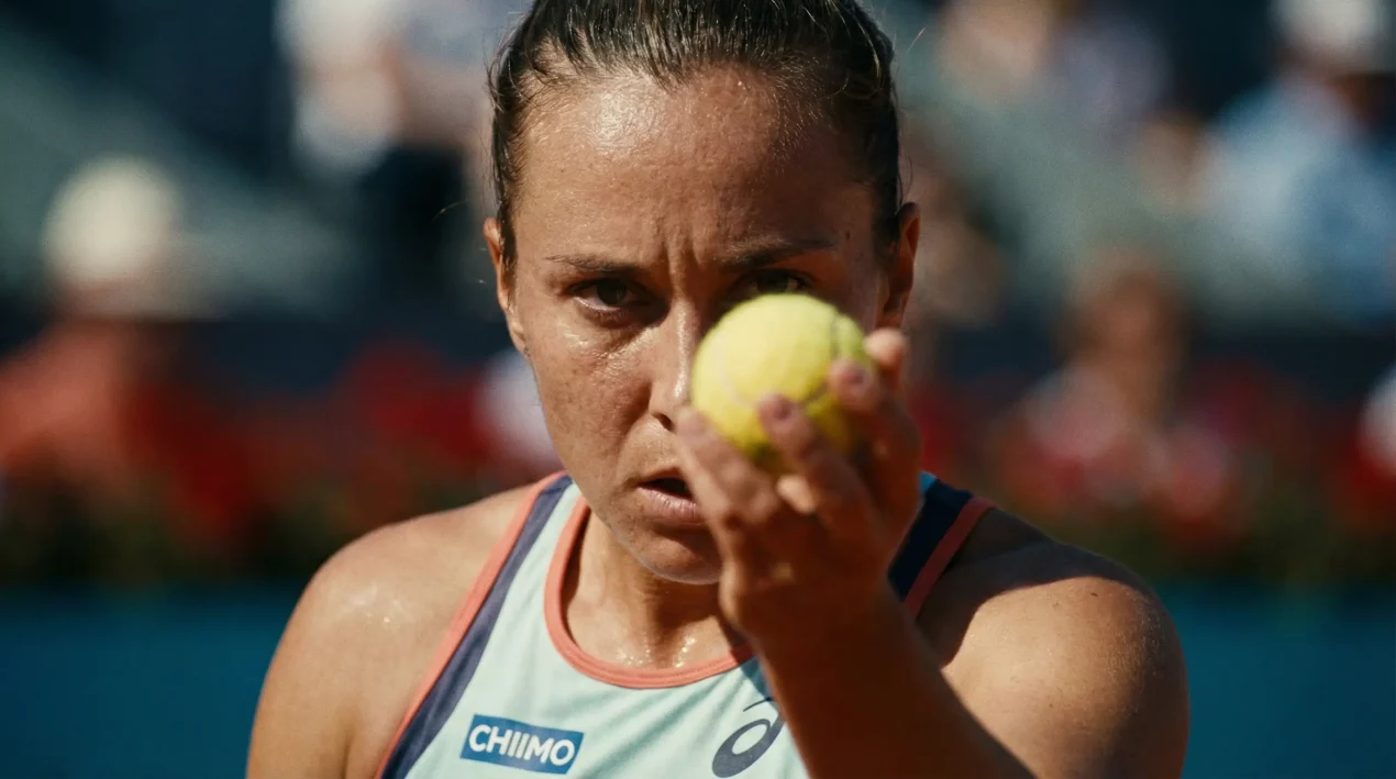 Tenista femenina concentrada con mirada intensa antes de servir un punto importante del partido