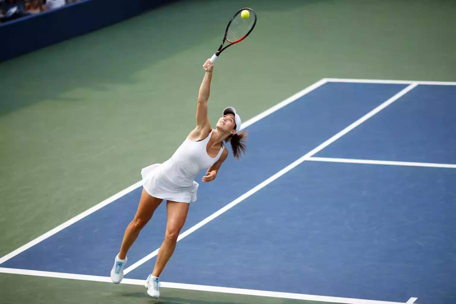 Tenista ejecutando potente servicio en partido WTA